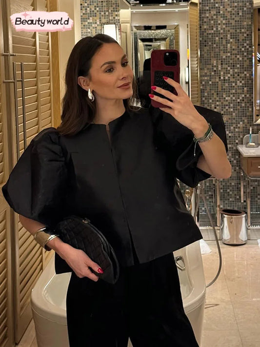 Blusa de manga abombada de satén con cuello redondo y una botonadura